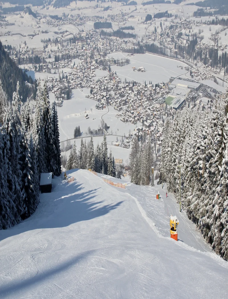 Blick über die Skipiste bis verschneite ins Tal.