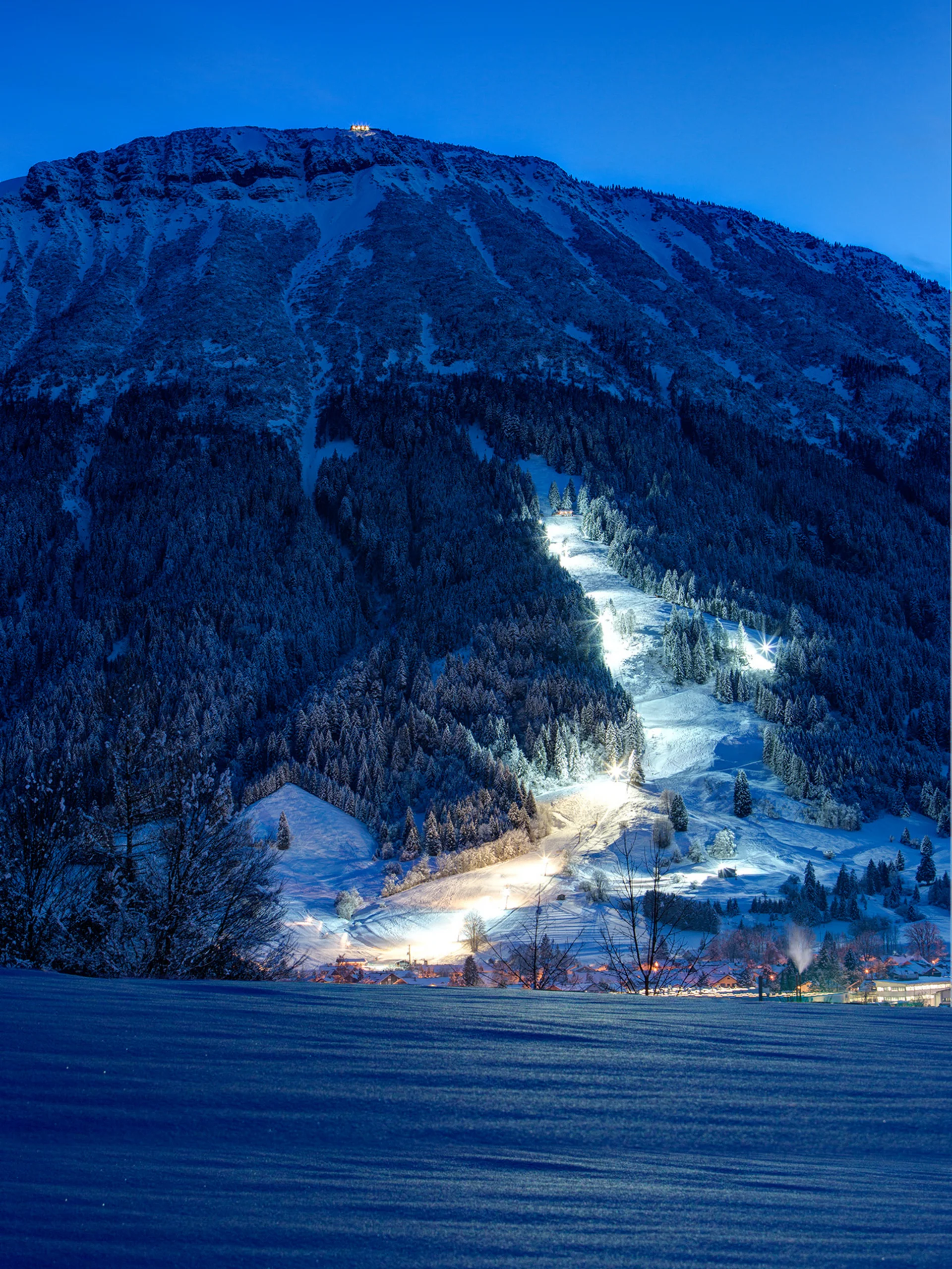 Die erleuchtete Flutlichtpiste strahlt durch die Nacht.